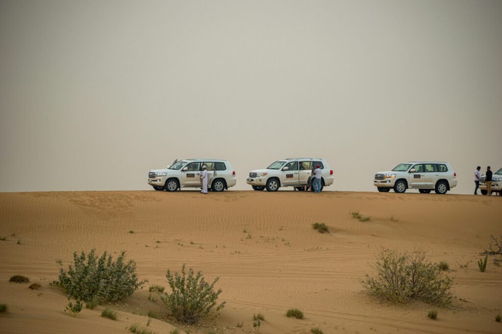 White SUVs on a thrilling desert safari in Dubai's sandy landscape, United Arab Emirates.