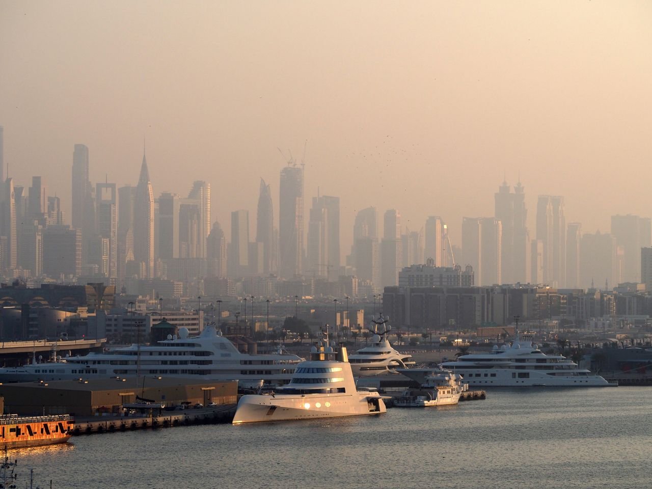 Offerings Dubai Marina with luxury yachts against a skyline of iconic skyscrapers in the morning light.